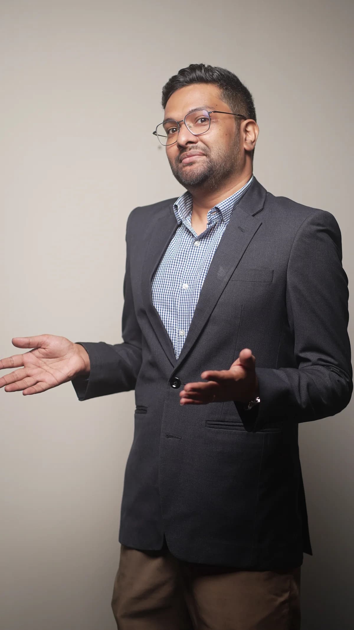 Dr. Adam with both hands open in a conversational gesture.