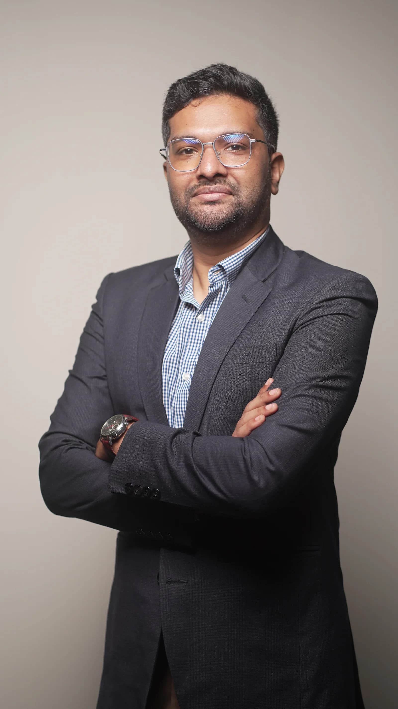 Dr. Md. Jurdi Adam in a dark blazer, standing with his arms folded.